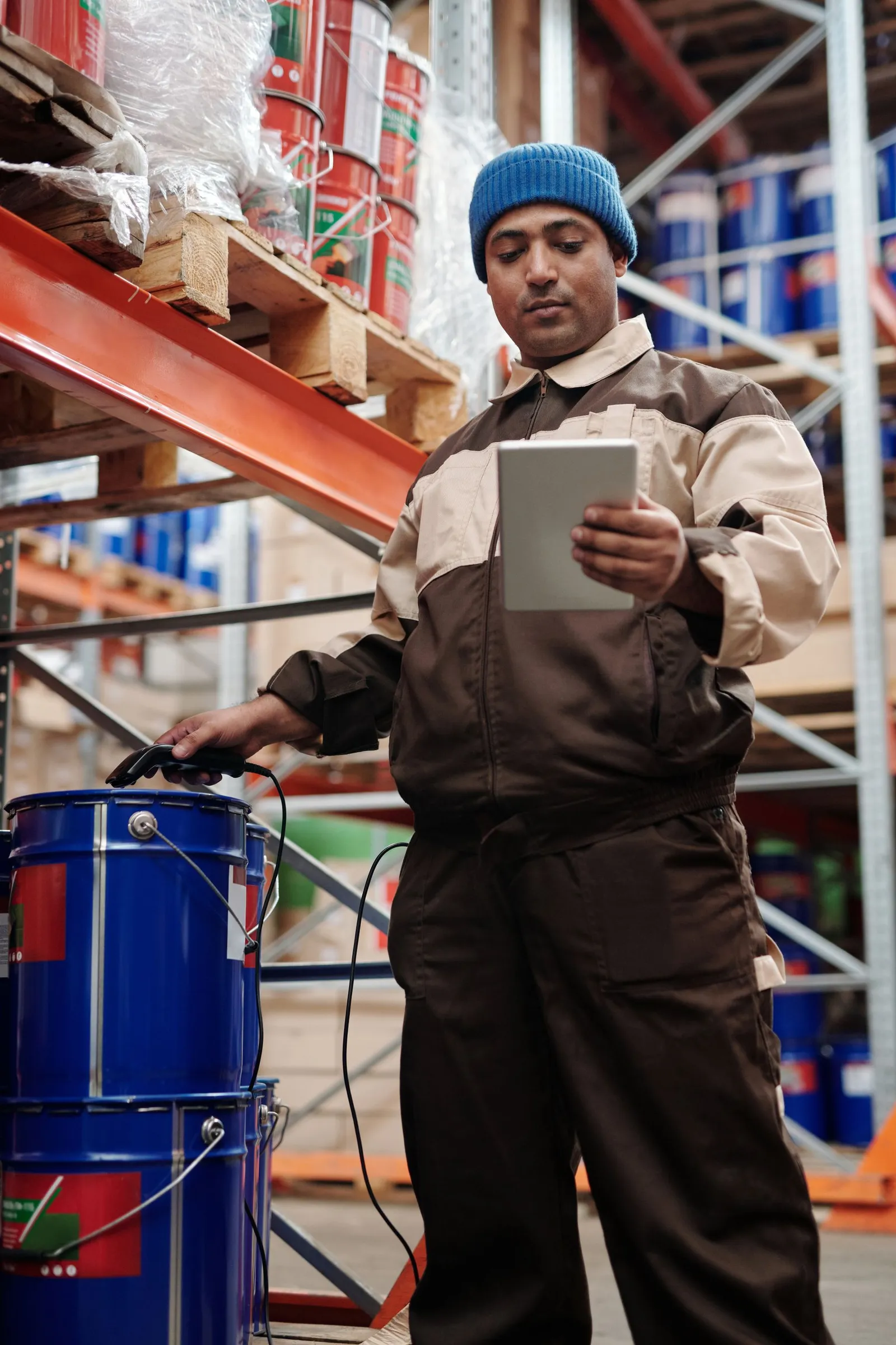 A worker in a stores area checking a job on a tablet