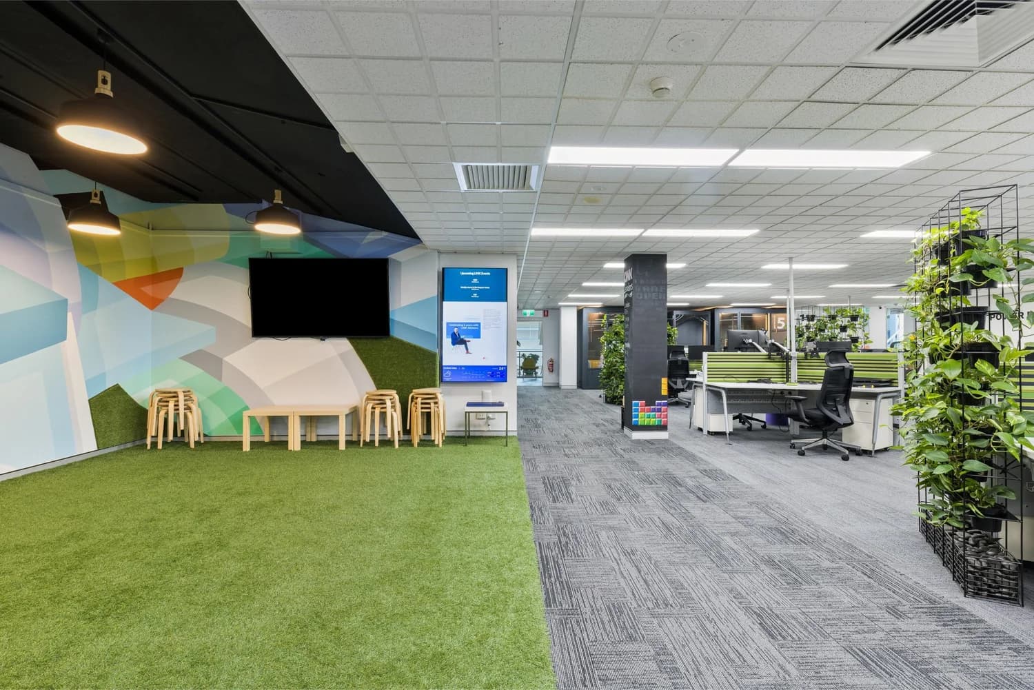 Studio floor with turf and presentation screen at LINK Coworking